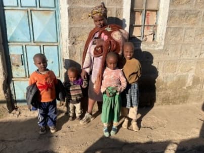 A mother with her children in front of their home in Kenya