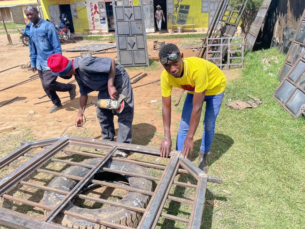 Auszubildende arbeiten in Kenia an einem Metallgitter